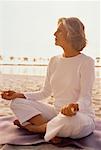 Mature Woman Doing Yoga on Beach At Sunset, Florida, USA