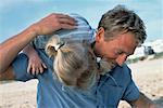 Father Carrying Daughter on Shoulder on Beach