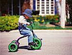 Garçon Tricycle devant la maison d'équitation