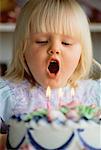 Girl Blowing Out Candles on Birthday Cake