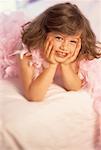 Portrait de jeune fille allongée sur le lit portant Boa rose