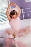 Portrait of Girl Sitting on Bed Wearing Ballerina Costume