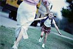 Daughter Running towards Mother Near School Bus