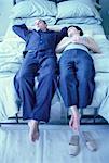 Paar entspannenden auf Bett mit Beine über die Kante hängen