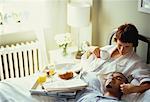 Couple allongé sur le lit avec petit déjeuner plateau