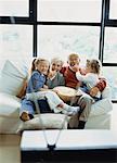 Grandparents and Granddaughters Sitting on Sofa, Watching TV