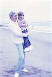 Großmutter Holding Enkelin am Strand