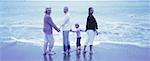 Portrait of Four Generations of Women Standing in Surf on Beach