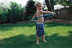 Portrait of Boy Using Hula Hoop Outdoors