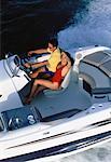 Couple en bateau, excès de vitesse sur l'eau de la baie de Biscayne, Floride, États-Unis