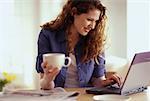 Young Woman Sitting at Table Using Laptop Computer