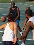 Four Men Playing Basketball Outdoors