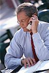 Mature Businessman Using Cell Phone at Outdoor Cafe