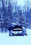 Homme mûr avec une voiture bloquée au bord de la route en hiver, ON, Canada