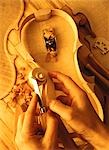Gros plan des mains de Luthiers découpant des morceaux pour violon