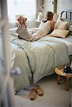 Back View of Woman Lying on Bed Reading Book