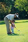 Father Teaching Child To Play Golf