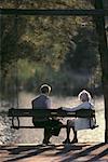 Back View of Mature Couple on Swing in Park, Miami, FL, USA