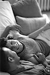 Couple Relaxing on Sofa, Laughing