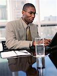 Businessman Sitting at Table Using Laptop Computer