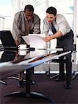 Two Businessmen at Table, Reading Documents