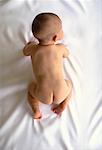 Overhead View of Nude Baby Crawling on Bed