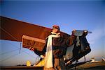 Pilot Holding Package, Standing Near Airplane