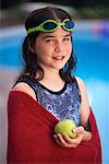 Portrait of Girl in Swimwear and Goggles, Holding Apple near Pool