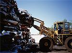 Machine Stacking Cars at Wrecking Yard