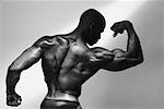 Back of Male Body Builder Flexing Muscles