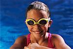 Portrait de jeune fille portant des maillots de bain et des lunettes dans la piscine