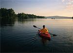 Vue arrière du femme kayak au coucher du soleil, lacs de Belgrade, ME, USA