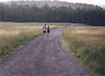 Back View of Couple Running on Dirt Road, Maine, USA