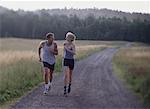 Couple Running on Dirt Road Maine, USA