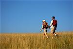 Couple Hiking through Field of Tall Grass, Holding Hands Belgrade Lakes, Maine, USA