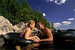 Couple dans le lac avec Inner Tubes Belgrade Lakes, Maine, États-Unis