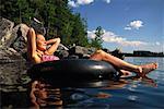 Woman Relaxing on Inner Tube in Lake, Belgrade Lakes, Maine, USA