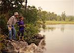 Grandfather and Grandson Fishing From Rocks, Belgrade Lakes, Maine USA