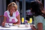 Deux femmes assises à Table en riant à l'extérieur