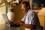 Man Sitting at Table Using Laptop Computer