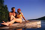 Couple en maillot de bain, reposant sur le quai, lacs de Belgrade, Maine, États-Unis