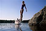 Paar in Bademode, Sprung ins Wasser von Felsen Belgrad Seen, Maine, USA