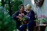 Älteres Paar mit Gartenarbeit Supplies, von Angesicht zu Angesicht im freien