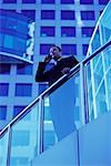 Homme d'affaires accoudée à une balustrade en utilisant un téléphone cellulaire, Toronto (Ontario) Canada