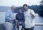 Portrait de grand-père, père et fils sur le pont avec des engins de pêche