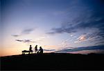 Father with Son and Daughter On Hill with Wagon at Sunset