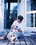 Mann sitzt auf dem Deck mit Hund Bala, Ontario, Kanada