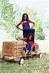 Portrait of Two Girls with Soapbox Car Outdoors