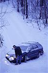 Mature Man Shovelling Snow in Front of Car