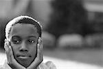 Portrait of Boy Sitting Outdoors Resting Head on Hands